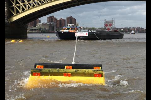 Looking down river through the central arch on a fast ebb tide, with the Port of London Authority launch moored in the distance